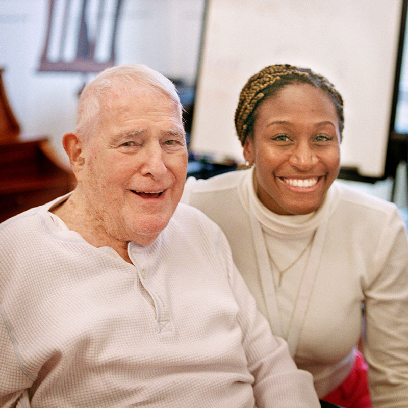 A smiling senior man with a female care worker