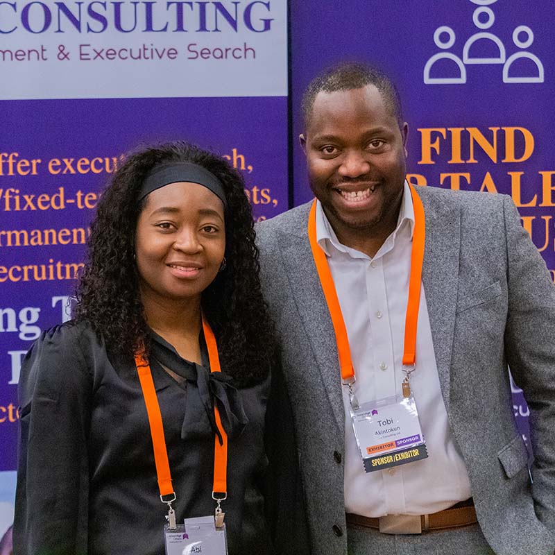Two commercial members at an event smiling at the camera