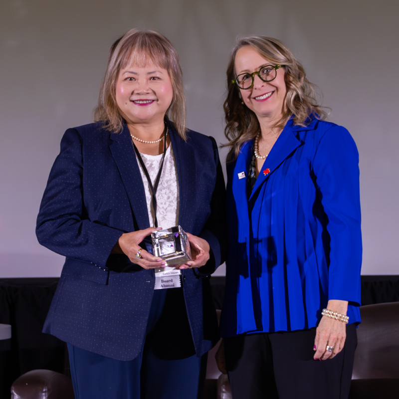 Honourary Member Soo Ching Kikuta accepts her recognition award standing next to CEO Lisa Levin on stage at Convention 2025